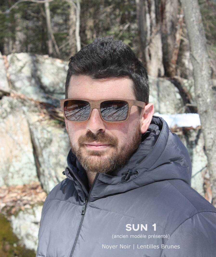 Young man wearing black walnut sunglasses with brown lenses.